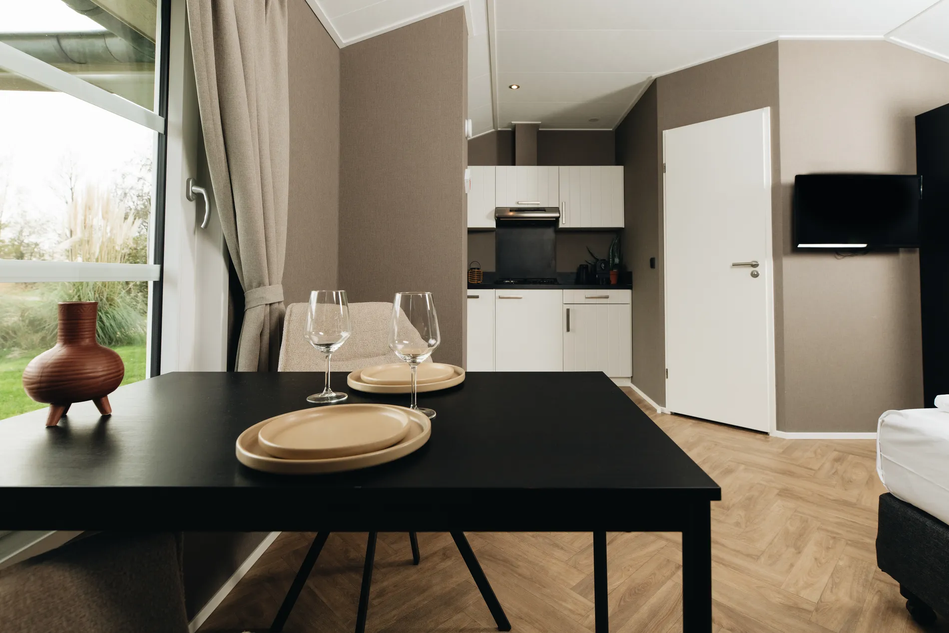Sfeervolle eethoek grenzend aan de moderne witte kitchenette, ideaal voor een zelfvoorzienend verblijf bij Resort Land & Zee.